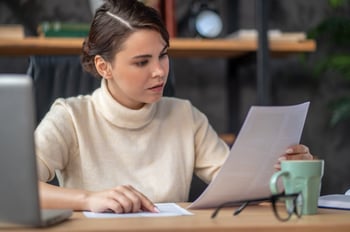 concentrated-lady-examining-documentation-desk