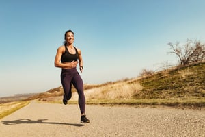 low-angle-view-happy-muscular-build-sportswoman-running-road-copy-space